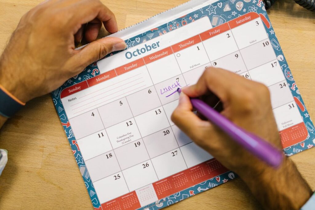 Persona marcando un día festivo en el calendario de octubre con un rotulador