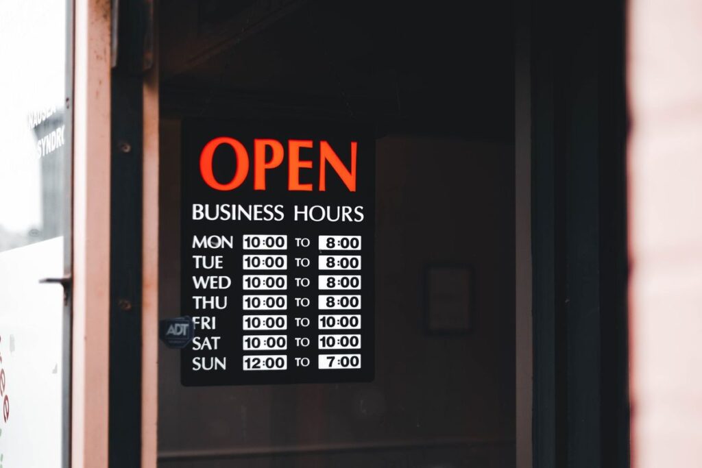 Cartel con el horario de apertura de cada día en el escaparate de una tienda